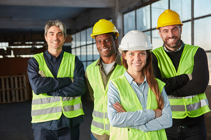 Logistics worker team with crossed arms in an industrial warehou Logistics worker team with crossed arms in an industrial warehouse